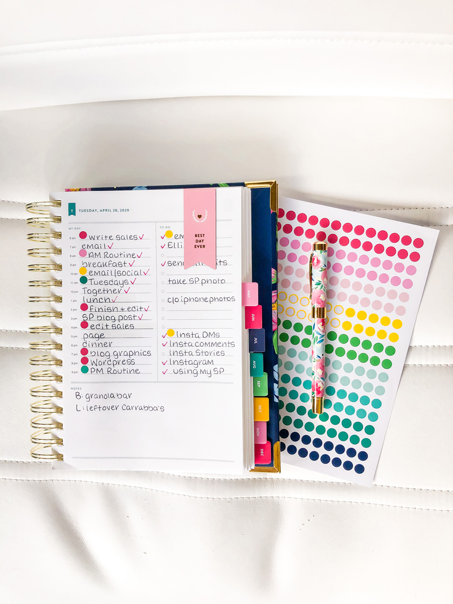 Daily Simplified Planner lying open with a sheet of color-coding stickers and happy floral pen