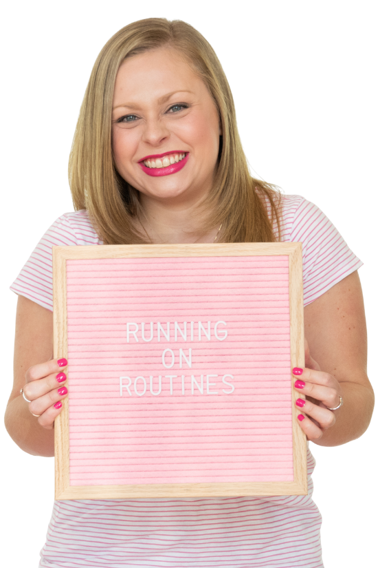 Alexandra of The Productivity Zone holding a pink letterboard with the words Running on Routines spelled out on it.