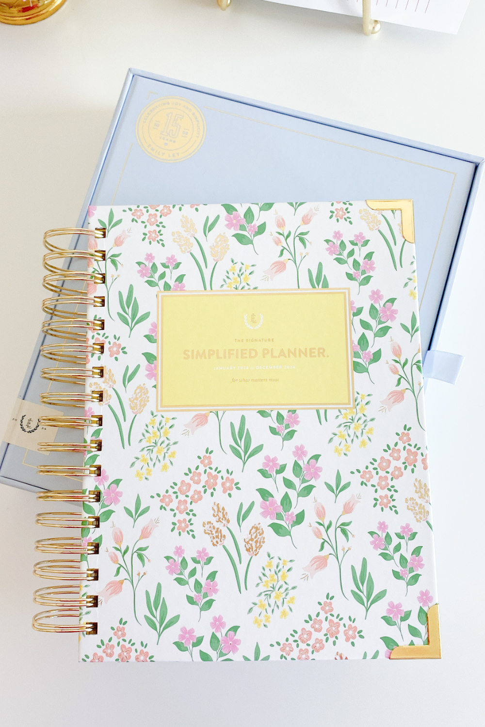 2024 Daily Simplified Planner in Golden Hour sitting on top of special edition light blue planner box